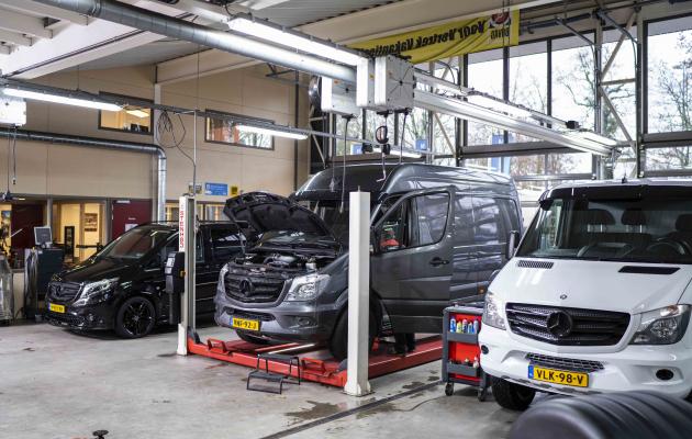 Twee bedrijfswagens in de garage voor onderhoud